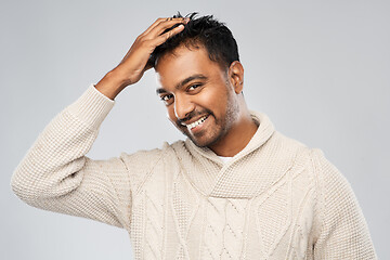 Image showing indian man in knitted sweater touching his hair