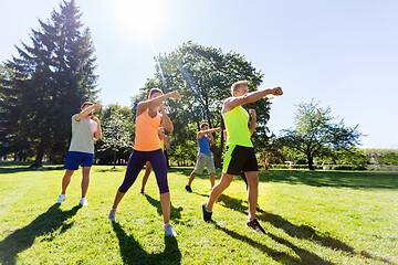 Image showing group of friends or sportsmen exercising at park