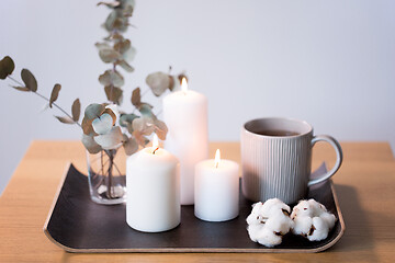 Image showing candles, tea and branches of eucalyptus on table