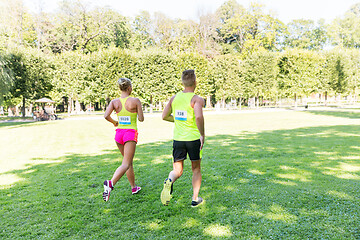 Image showing happy couple of sportsmen racing wit badge numbers