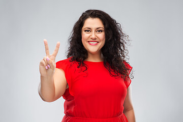 Image showing happy woman in red dress showing peace hand sign