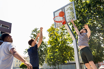 Image showing group of male friends playing street basketball