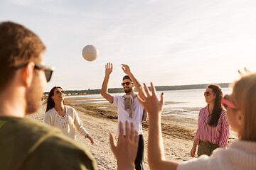 Image showing friends playing volleyball on beach in summer