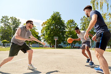 Image showing group of male friends playing street basketball