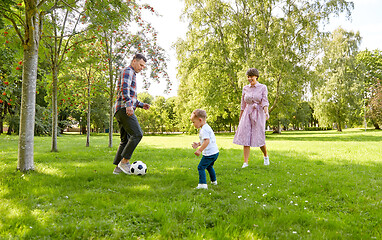 Image showing happy family playing soccer at summer park