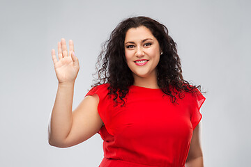 Image showing happy woman in red dress waving hand