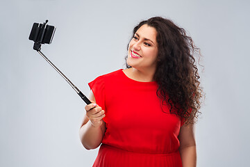 Image showing woman taking picture by smartphone on selfie stick