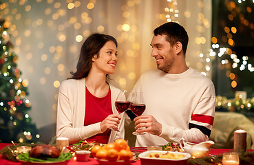 Image showing happy couple drinking red wine at christmas dinner