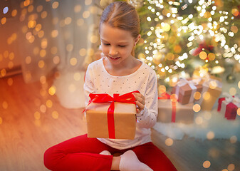 Image showing smiling girl with christmas gift at home