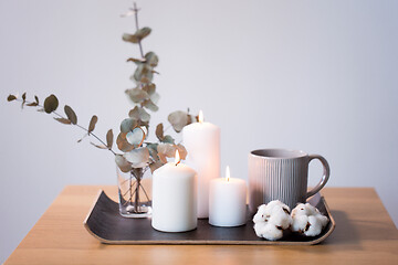 Image showing candles, mug and branches of eucalyptus on table