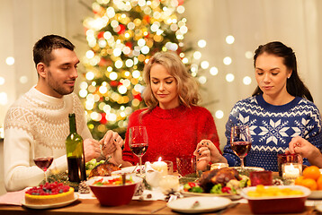 Image showing friends praying before christmas dinner at home