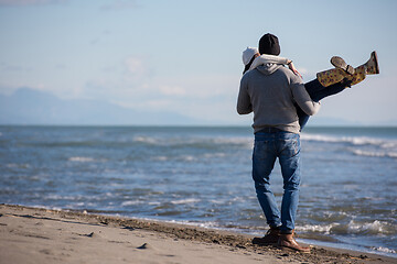 Image showing Loving young couple on a beach at autumn sunny day