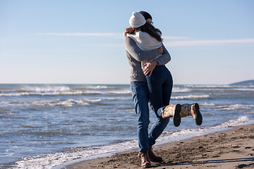 Image showing Loving young couple on a beach at autumn sunny day