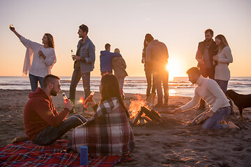 Image showing Couple enjoying with friends at sunset on the beach