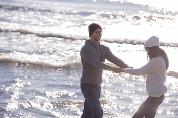 Image showing Loving young couple on a beach at autumn sunny day