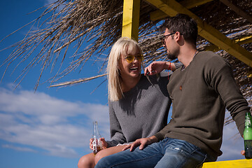 Image showing young couple drinking beer together at the beach