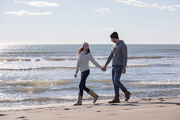 Image showing Loving young couple on a beach at autumn sunny day