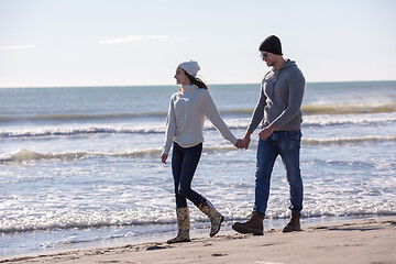 Image showing Loving young couple on a beach at autumn sunny day