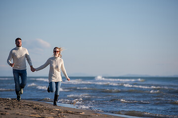 Image showing Loving young couple on a beach at autumn sunny day