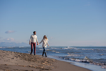 Image showing Loving young couple on a beach at autumn sunny day