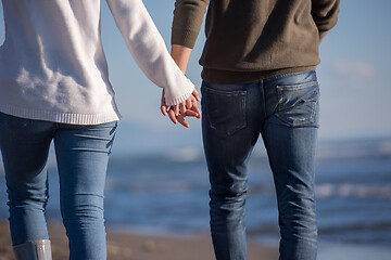 Image showing Loving young couple on a beach at autumn sunny day