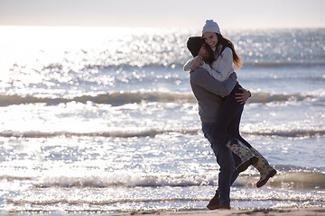 Image showing Loving young couple on a beach at autumn sunny day