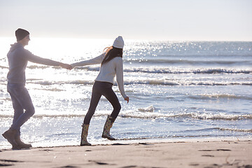 Image showing Loving young couple on a beach at autumn sunny day