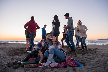 Image showing Couple enjoying with friends at sunset on the beach