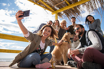 Image showing Group of friends having fun on autumn day at beach