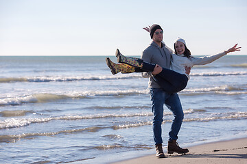 Image showing Loving young couple on a beach at autumn sunny day