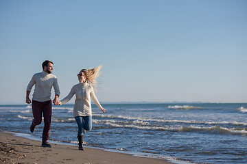 Image showing Loving young couple on a beach at autumn sunny day