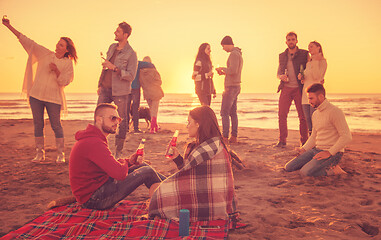 Image showing Couple enjoying with friends at sunset on the beach