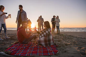 Image showing Couple enjoying with friends at sunset on the beach