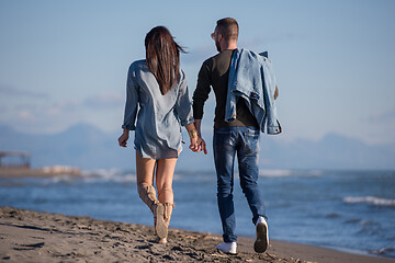 Image showing Loving young couple on a beach at autumn sunny day