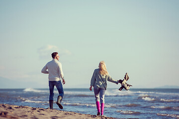 Image showing Loving young couple on a beach at autumn sunny day