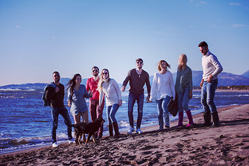 Image showing young friends jumping together at autumn beach