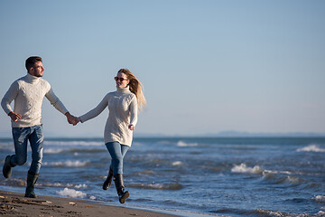 Image showing Loving young couple on a beach at autumn sunny day