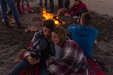 Image showing Couple enjoying bonfire with friends on beach