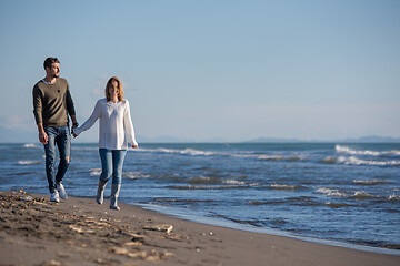 Image showing Loving young couple on a beach at autumn sunny day