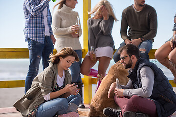 Image showing Group of friends having fun on autumn day at beach