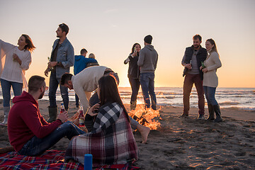 Image showing Couple enjoying with friends at sunset on the beach