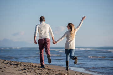 Image showing Loving young couple on a beach at autumn sunny day