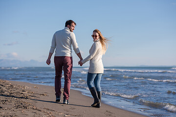 Image showing Loving young couple on a beach at autumn sunny day