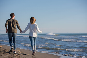 Image showing Loving young couple on a beach at autumn sunny day