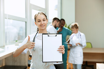 Image showing Beautiful smiling doctor over hospital background