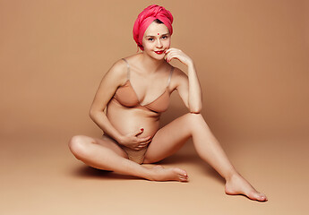 Image showing Young beautiful pregnant woman posing on brown background