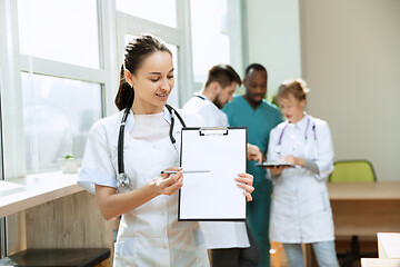 Image showing Beautiful smiling doctor over hospital background