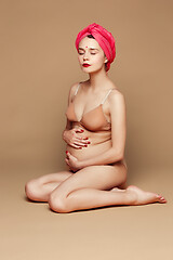 Image showing Young beautiful pregnant woman posing on brown background