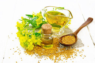 Image showing Oil mustard in jars and gravy boat on white board