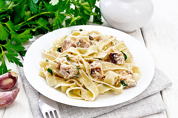 Image showing Pasta with salmon and cream on wooden board